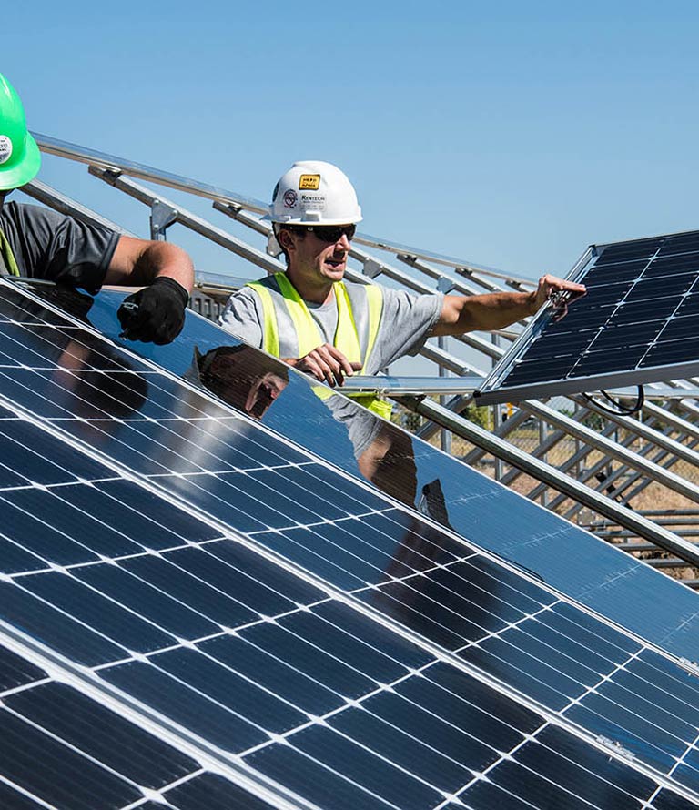 Two workers installing solar panels.