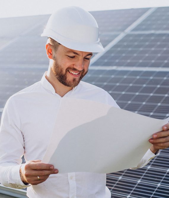 Man in hardhat reviewing solar panel plans.