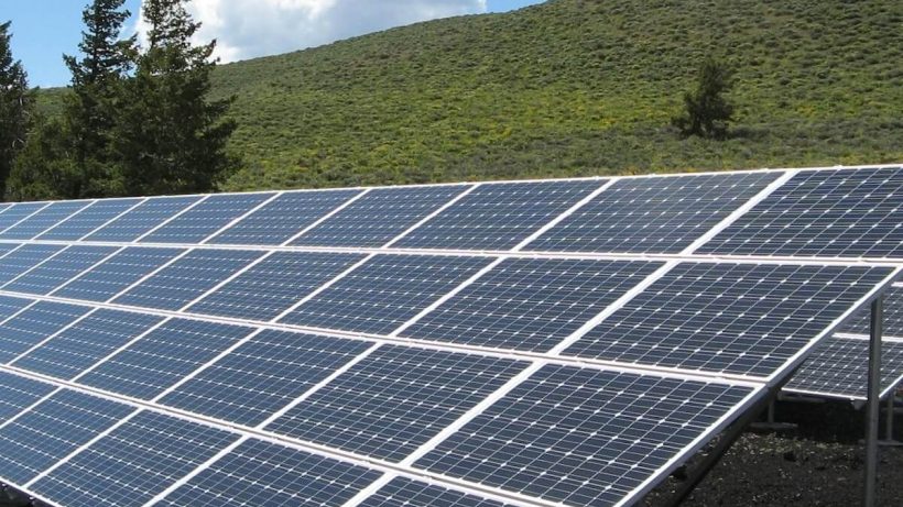 Solar panels on a grassy hill.