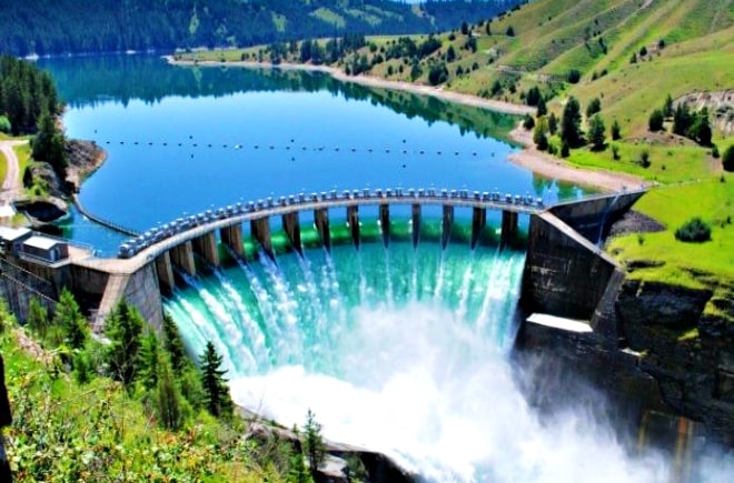 Large dam releasing water into lake.