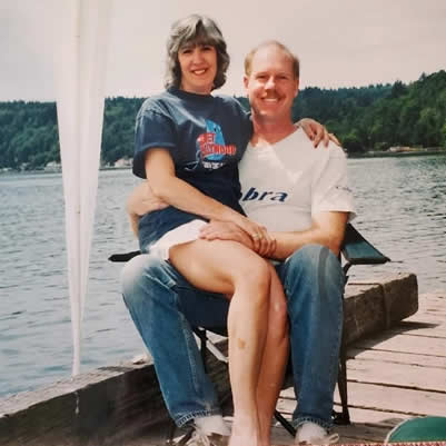 Couple sitting on a dock by the water.