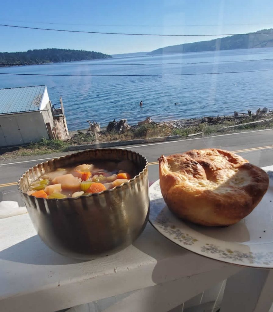 Soup and bread by a waterfront view.